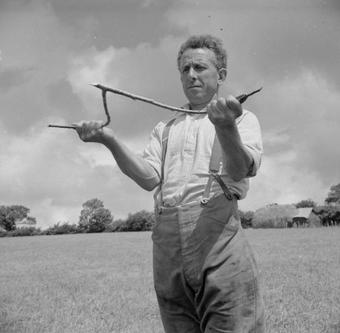 A man practicing water dowsing in the 1940s UK